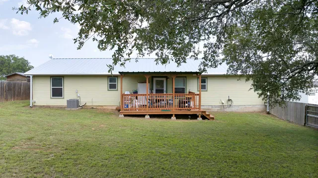 a view of a house with wooden deck and furniture