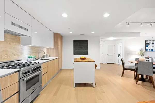 a kitchen with stainless steel appliances a stove a sink a counter top space and cabinets
