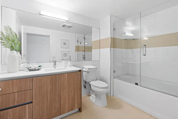 a bathroom with a sink a toilet and shower