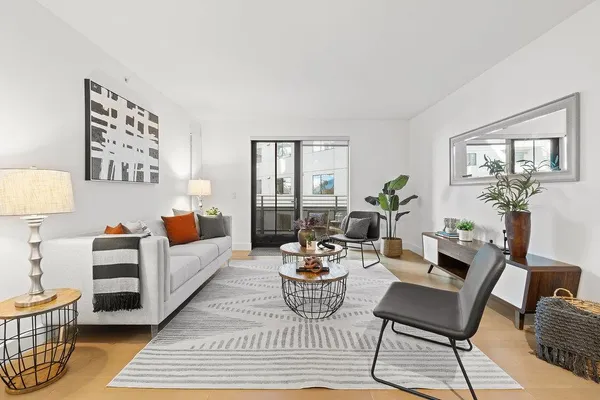 a living room with furniture and a potted plant on a table