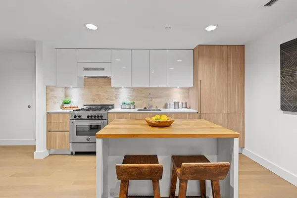 a kitchen with a sink a stove and chairs
