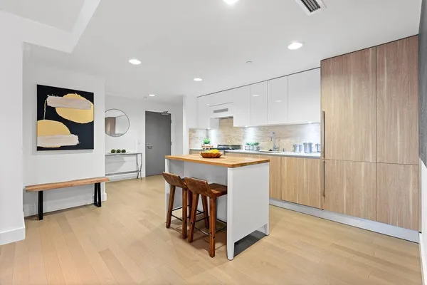 a open kitchen with white cabinets and stainless steel appliances