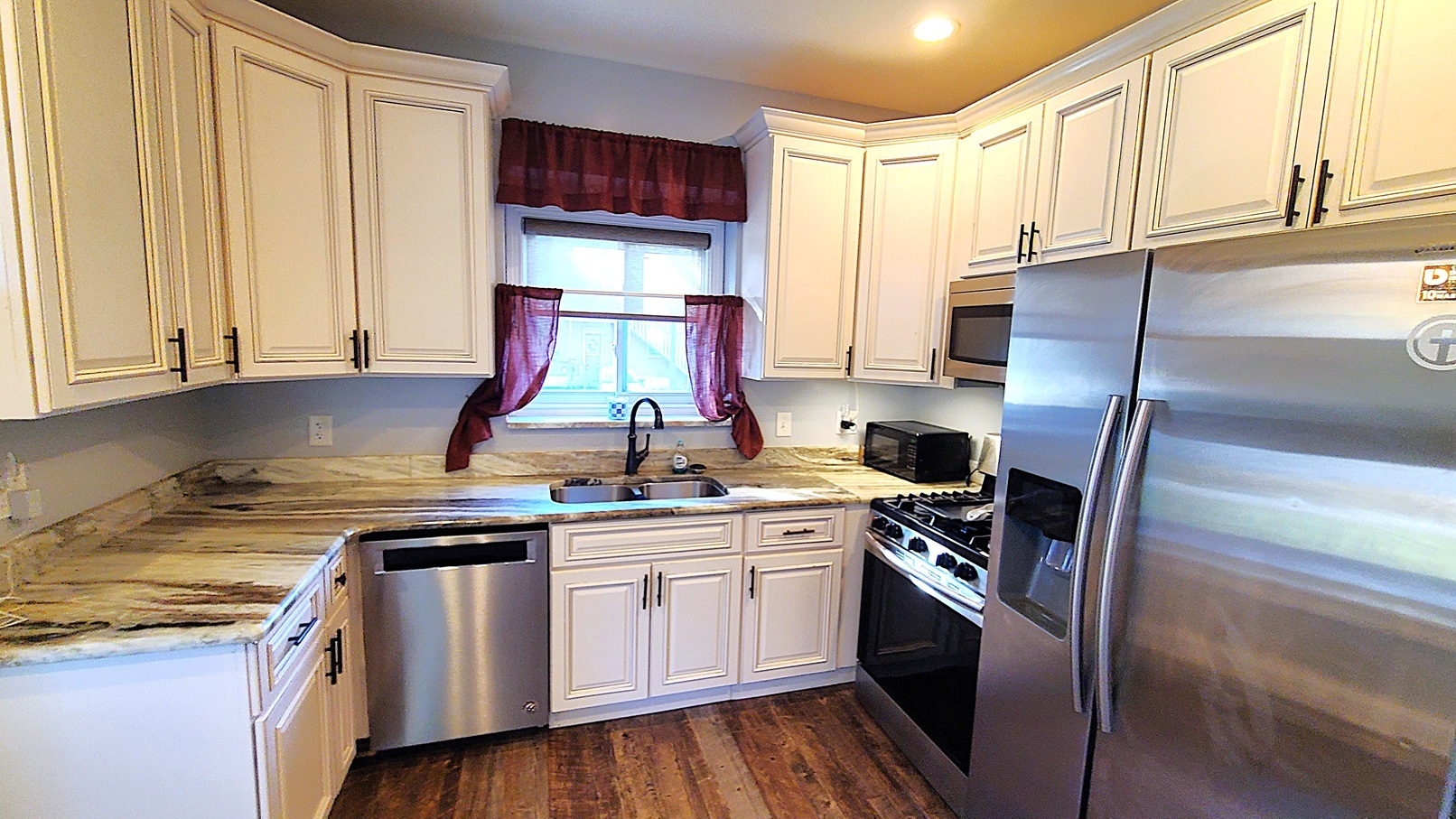 405 North Center Street Plano, IL 60545 - Photo 9 of 35 a kitchen with kitchen island granite countertop a sink a counter space appliances and cabinets