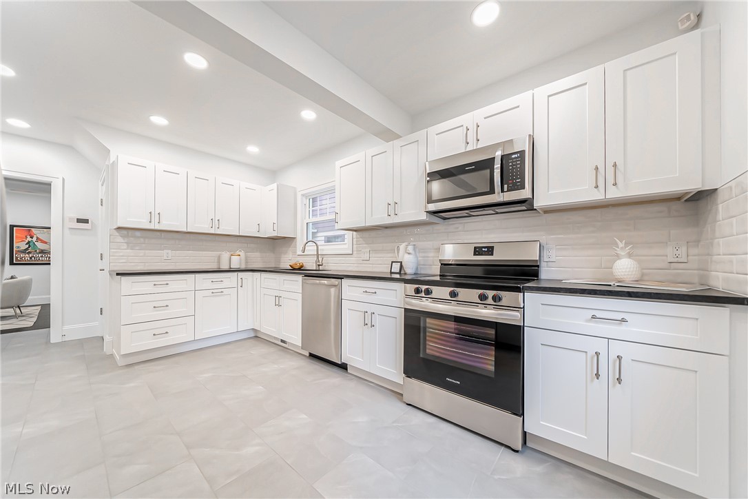 3947 Rosemond Road Cleveland Heights, OH 44121 - Photo 15 of 44 Kitchen featuring sink, backsplash, white cabinetry, and appliances with stainless steel finishes