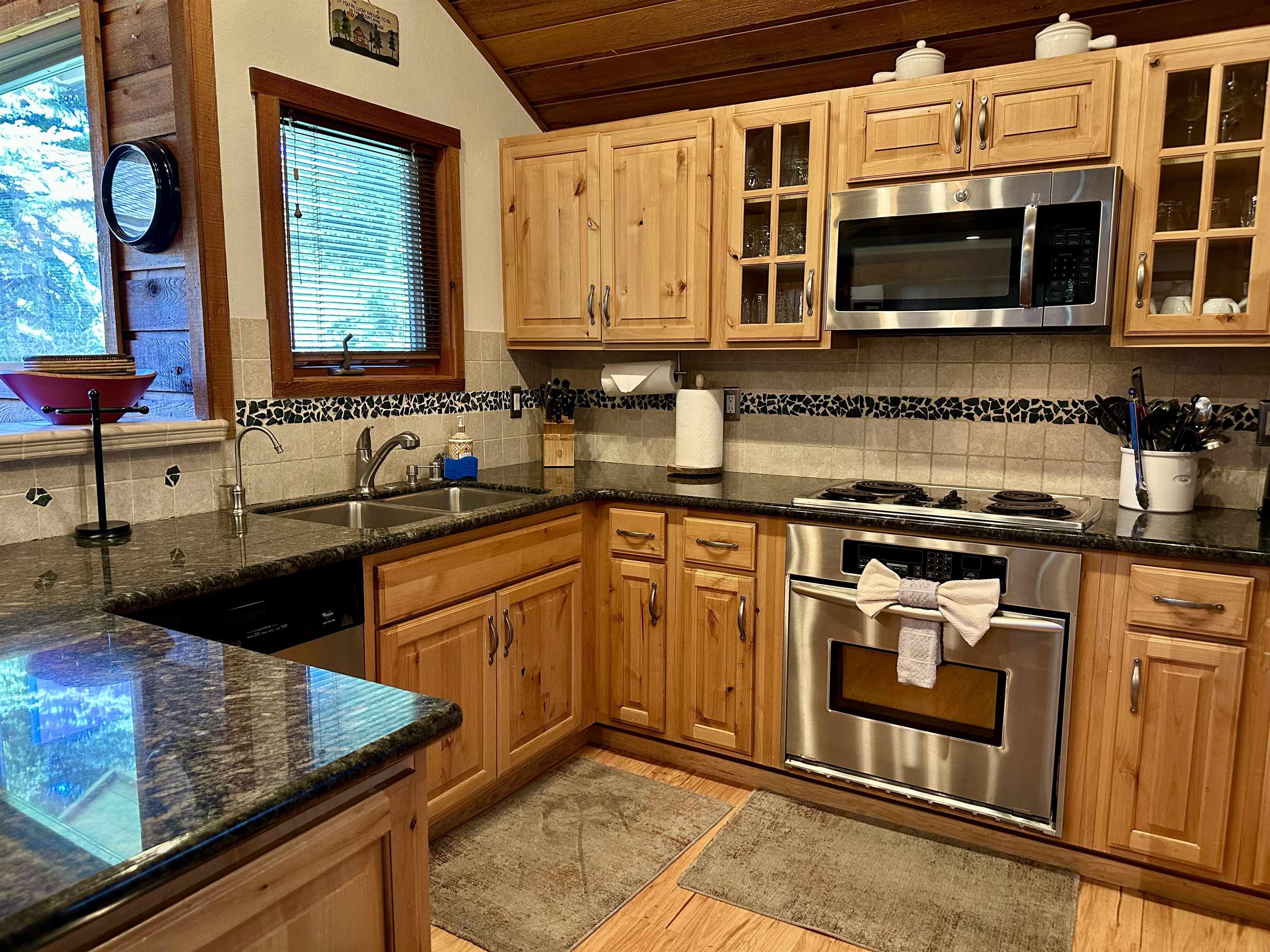 315 Fascination, Unit 315 Mammoth Lakes, CA 93546 - Photo 28 of 44 Kitchen featuring natural wood cabinetry, dark countertops, and stainless steel appliances