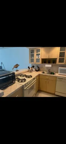 a view of kitchen island with sink stainless steel appliances and living room