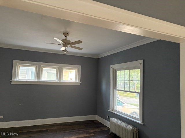 3258 Berkshire Road Cleveland, OH 44118 - Photo 10 of 23 Spare room featuring radiator heating unit, plenty of natural light, dark wood-type flooring, ornamental molding, and a ceiling fan