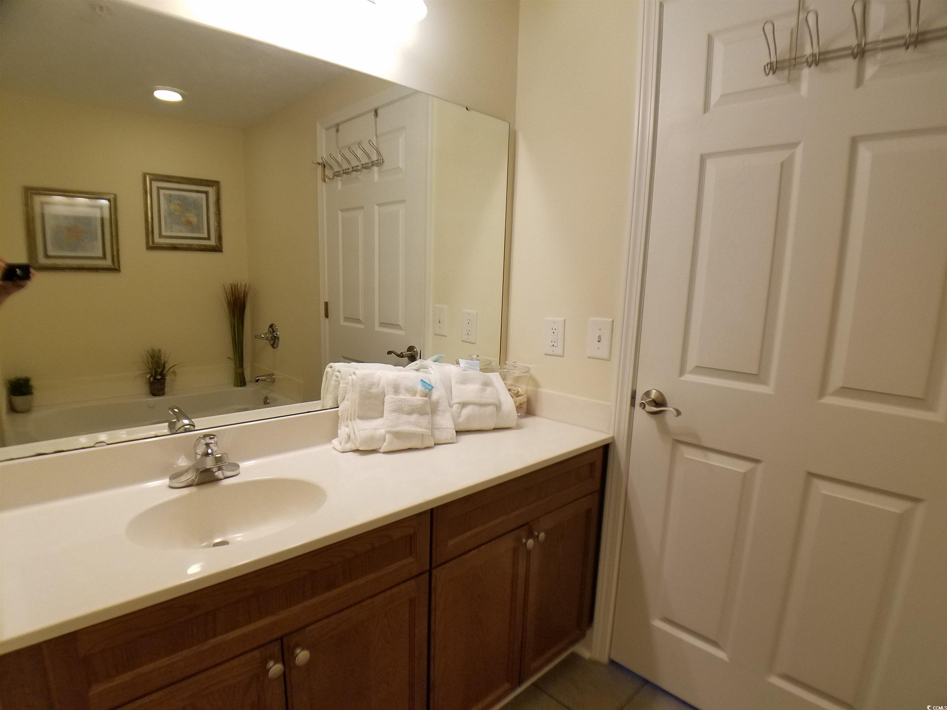 704 South Ocean Boulevard, Unit 101B Myrtle Beach, SC 29577 - Photo 12 of 25 Bathroom with vanity, a bath, and tile patterned floors