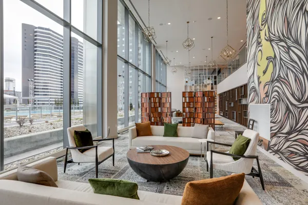 a living room with couches a coffee table and chairs with wooden floor