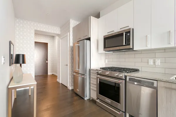 a kitchen with stainless steel appliances wooden cabinets and a stove top oven
