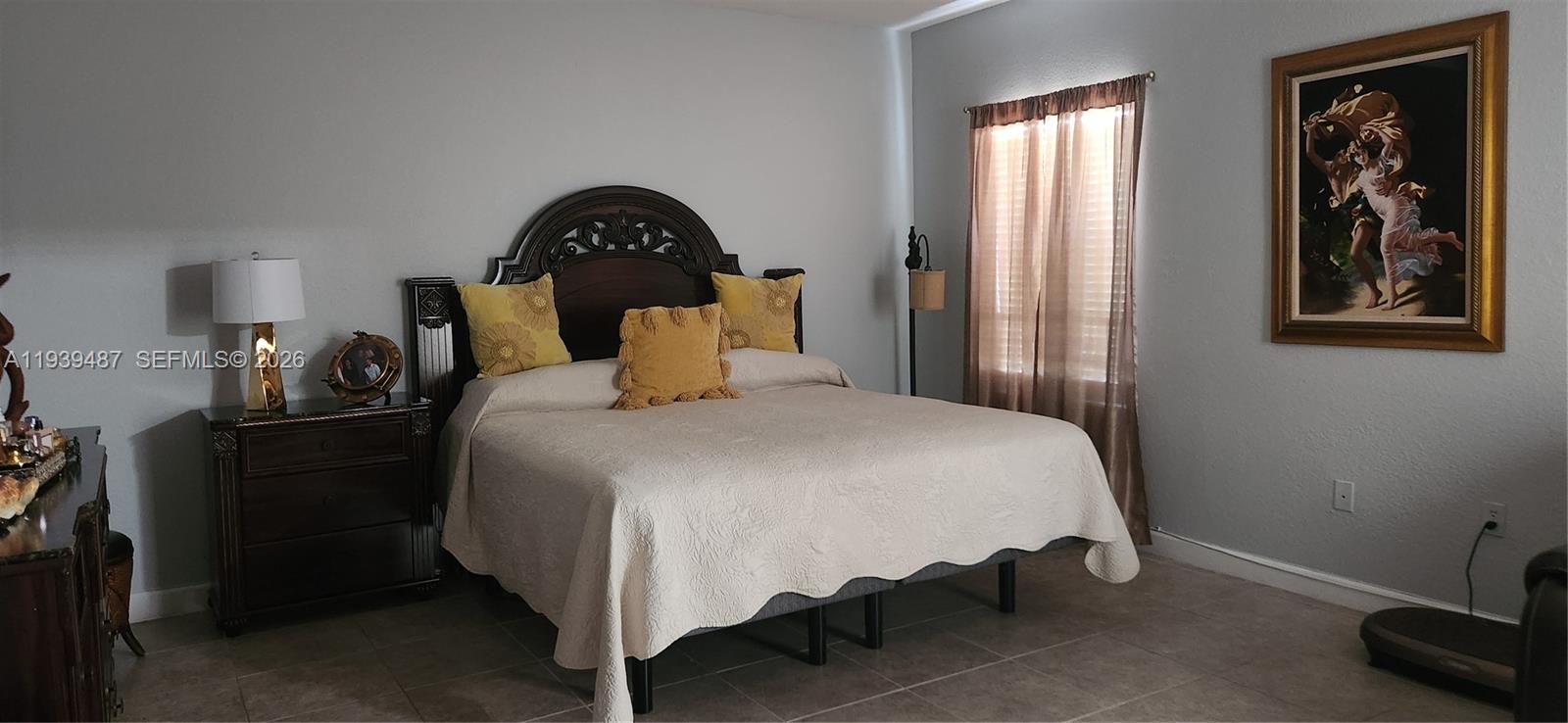 11382 Southwest 242nd Street Homestead, FL 33032 - Photo 14 of 21 a bedroom with a bed and a painting on the wall