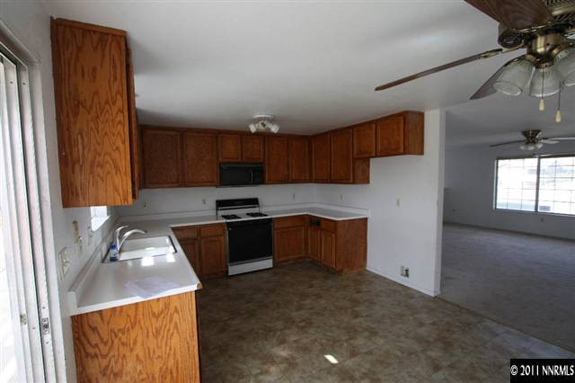 261 River Boat Road Dayton, NV 89403 - Photo 4 of 13 a kitchen with granite countertop a sink a counter space appliances and cabinets