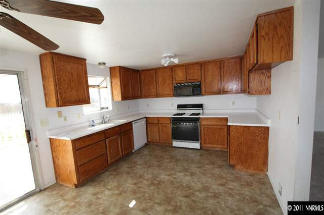 261 River Boat Road Dayton, NV 89403 - Photo 5 of 13 a kitchen with granite countertop a sink cabinets and stainless steel appliances