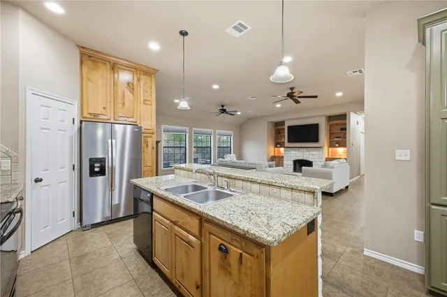 a kitchen with stainless steel appliances granite countertop a sink and refrigerator