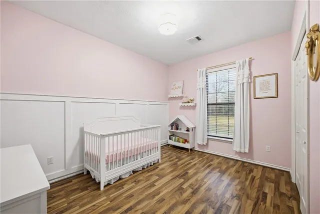 a view of a bedroom with wooden floor
