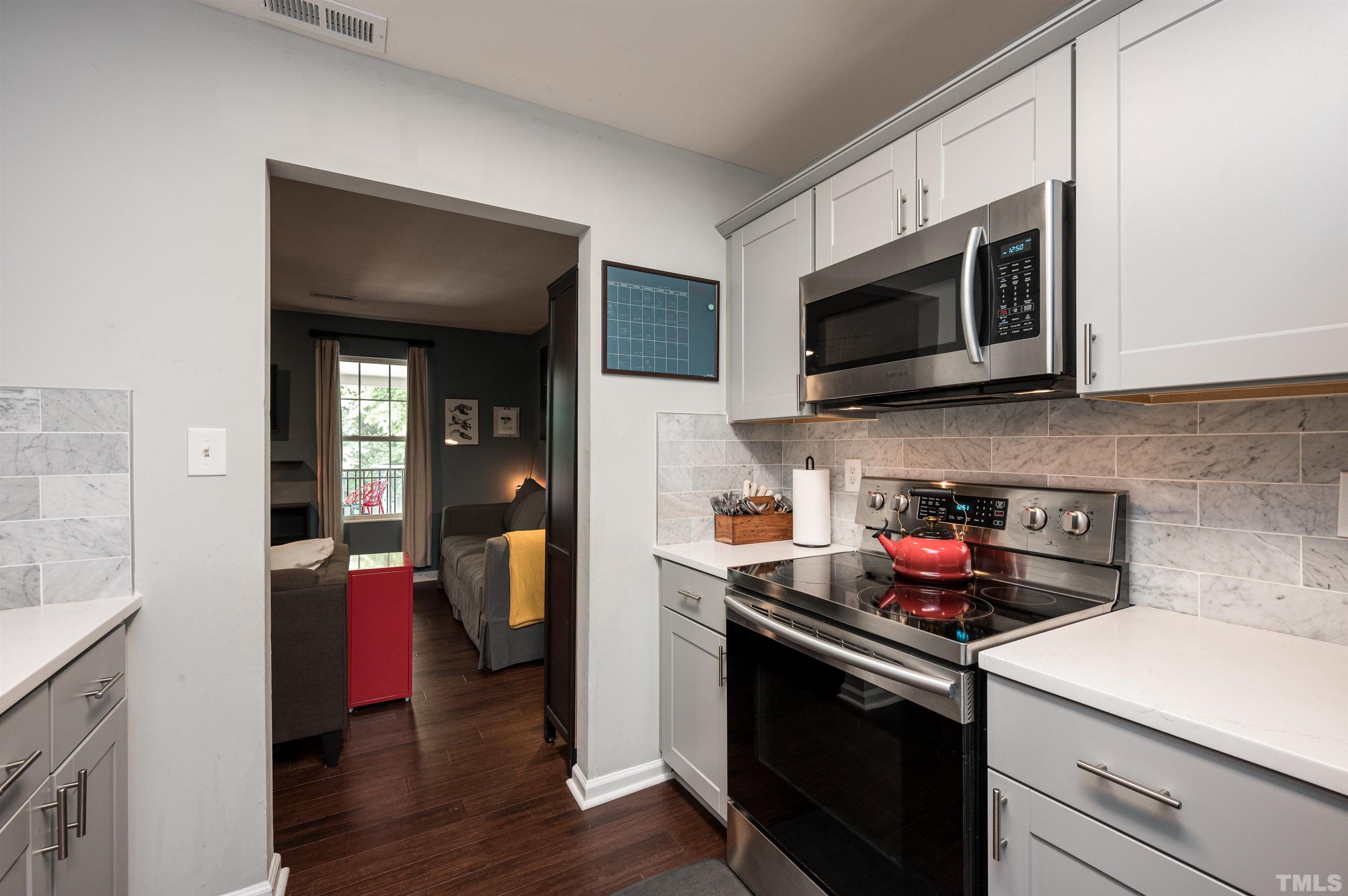 704 Quarry Street Raleigh, NC 27601 - Photo 18 of 27 a kitchen with stainless steel appliances granite countertop a stove microwave and sink