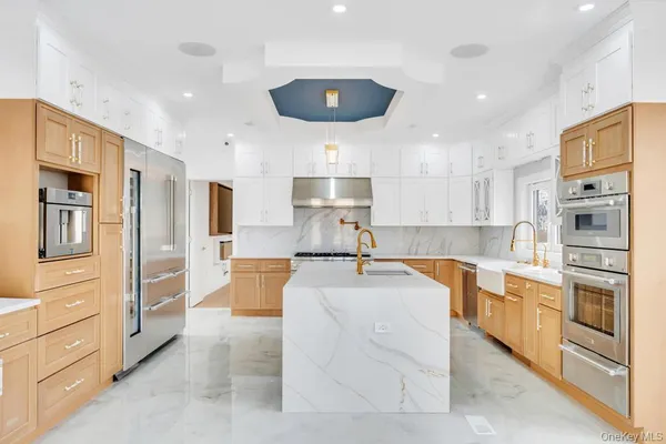 a large kitchen with stainless steel appliances lots of counter space and wooden floor