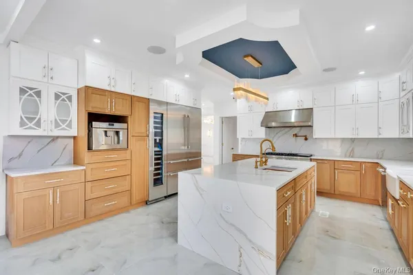 a kitchen with stainless steel appliances granite countertop a sink and a refrigerator
