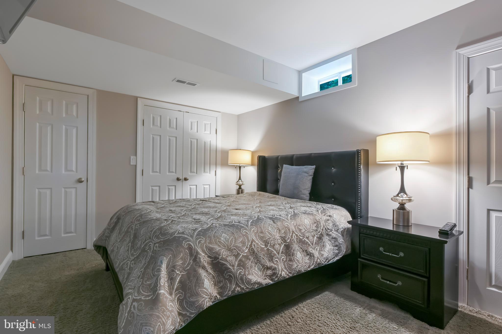 1613 Braid Hills Drive Pasadena, MD 21122 - Photo 138 of 148 a bedroom with a bed and a lamp