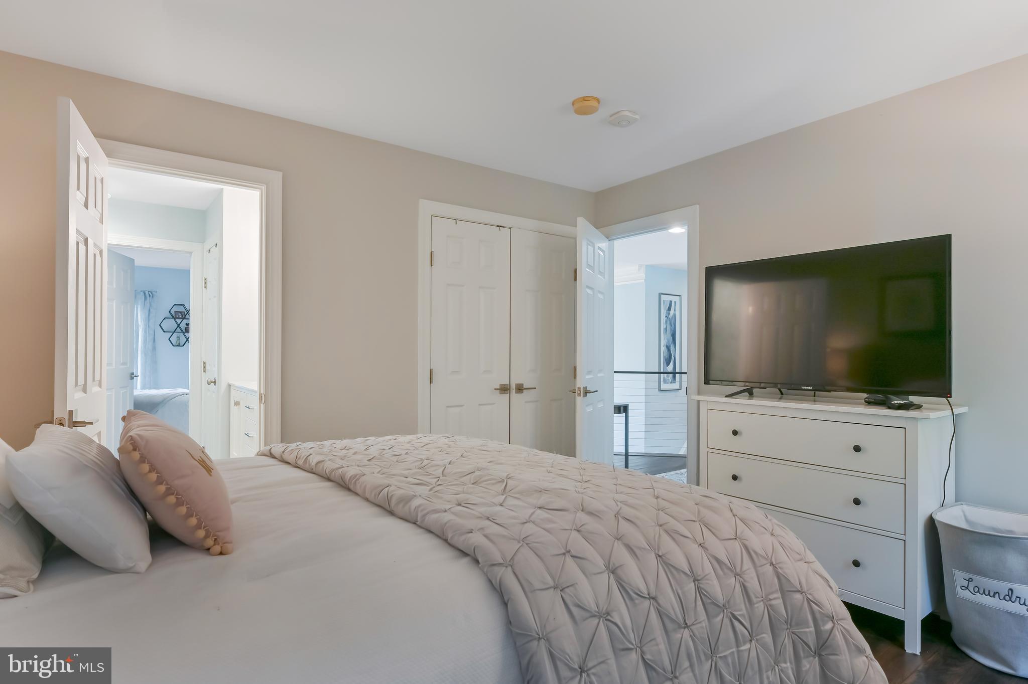 1613 Braid Hills Drive Pasadena, MD 21122 - Photo 74 of 148 a bedroom with a bed and a flat screen tv in white bedroom