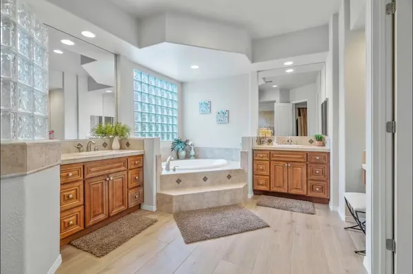 a large bathroom with a double vanity sink a mirror and a bathtub