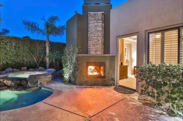 a view of a patio with a table and chairs and a fire pit