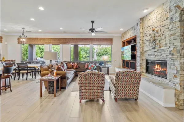 a living room with furniture a large window and a fireplace