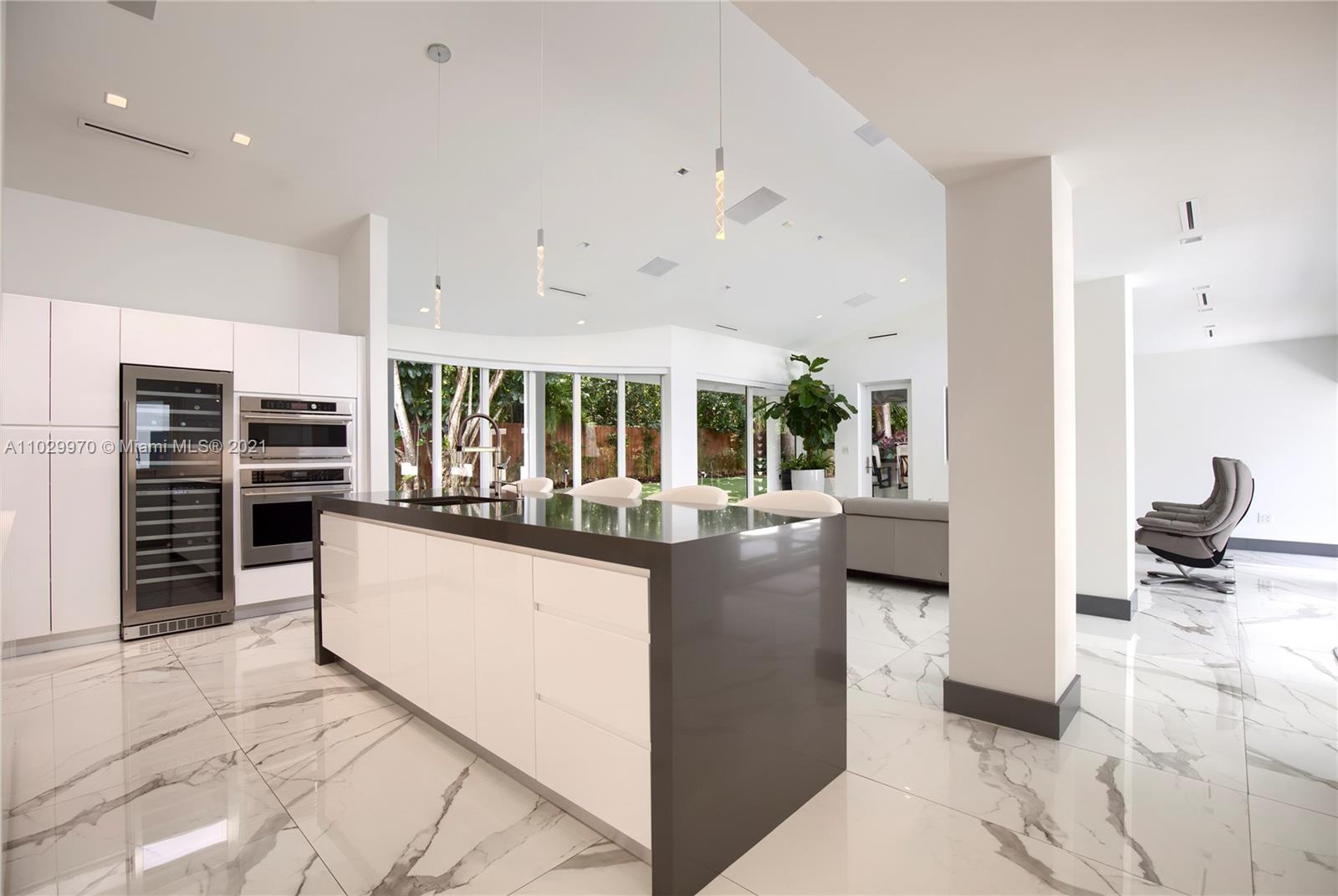 6460 Southwest 133rd Drive Pinecrest, FL 33156 - Photo 21 of 52 a kitchen with stainless steel appliances kitchen island granite countertop a refrigerator and a sink