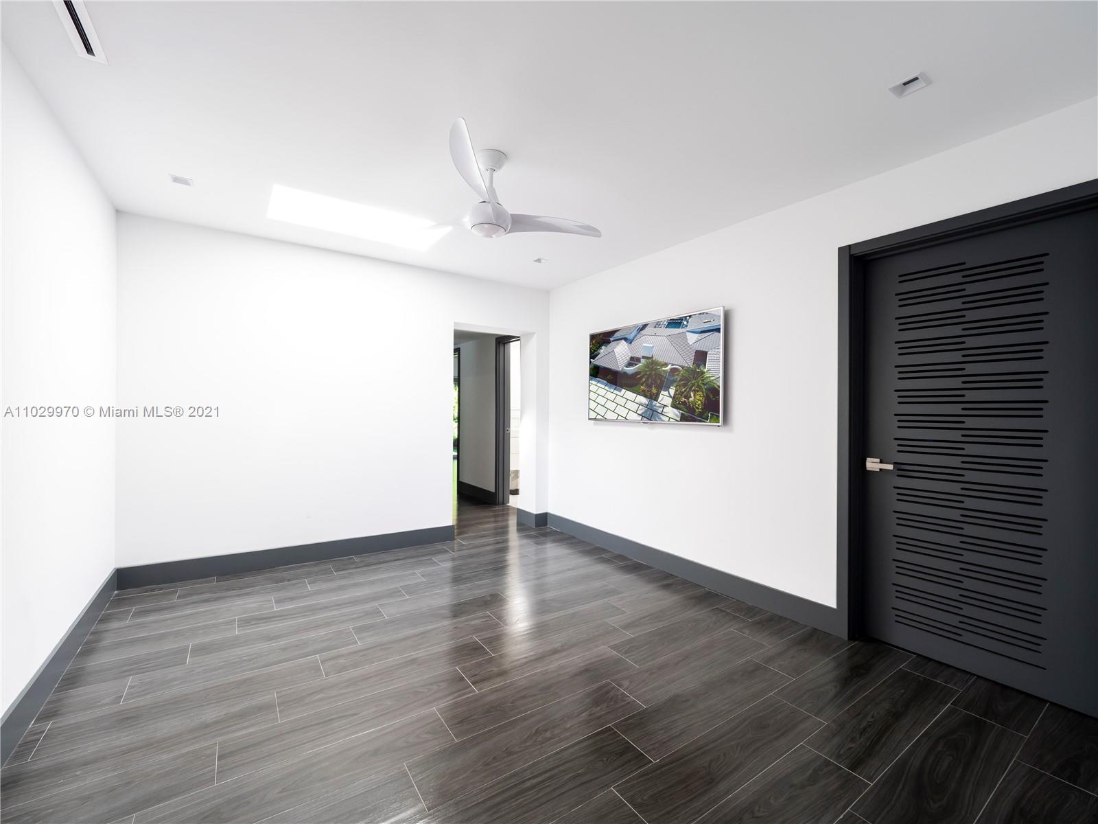 6460 Southwest 133rd Drive Pinecrest, FL 33156 - Photo 25 of 52 a view of an empty room with wooden floor and a ceiling fan