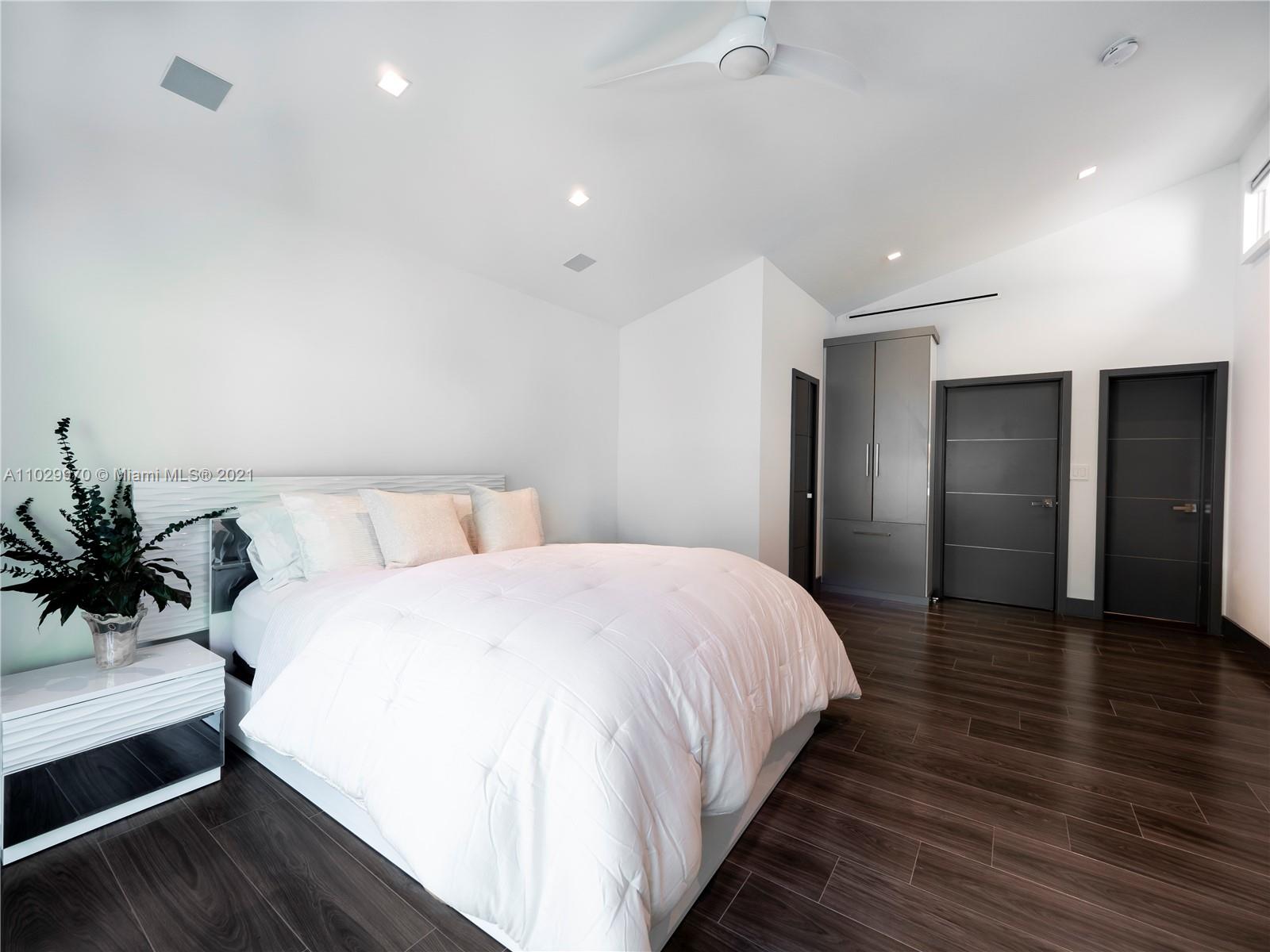 6460 Southwest 133rd Drive Pinecrest, FL 33156 - Photo 38 of 52 a spacious bedroom with a bed and a potted plant