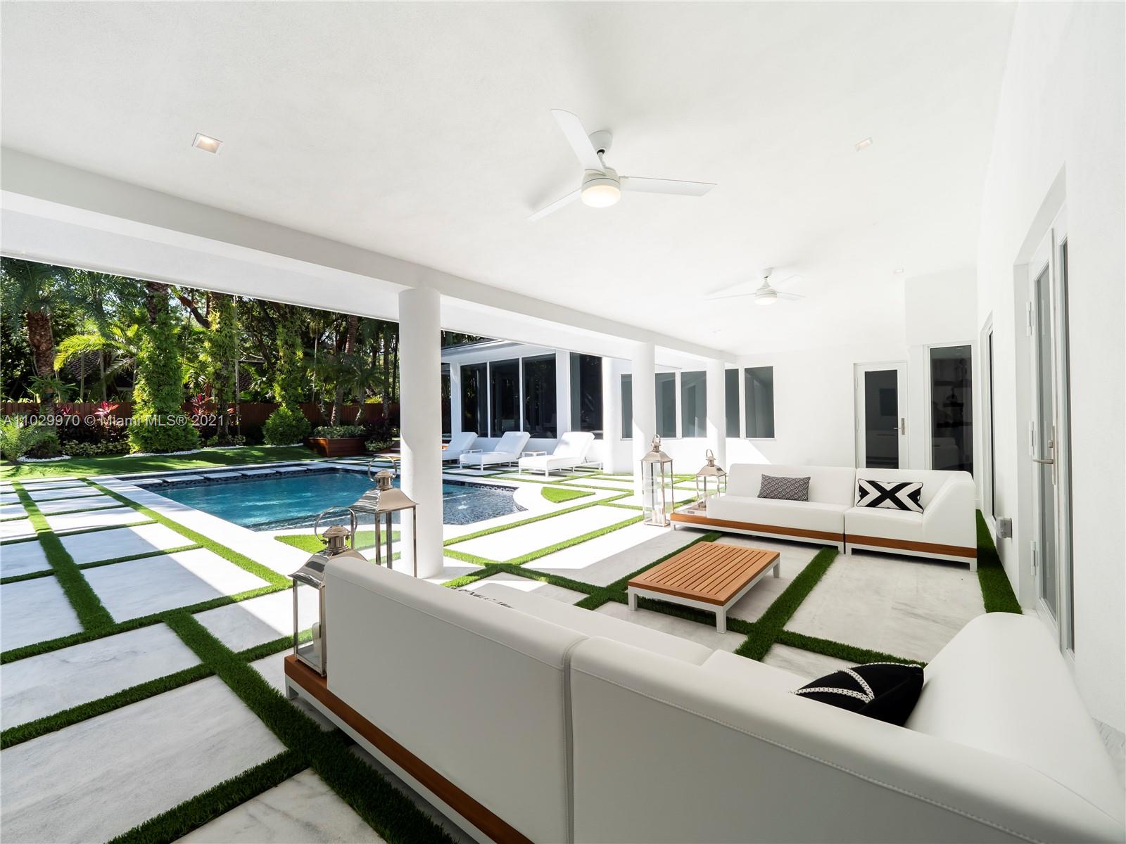 6460 Southwest 133rd Drive Pinecrest, FL 33156 - Photo 46 of 52 a living room with patio furniture and floor to ceiling windows