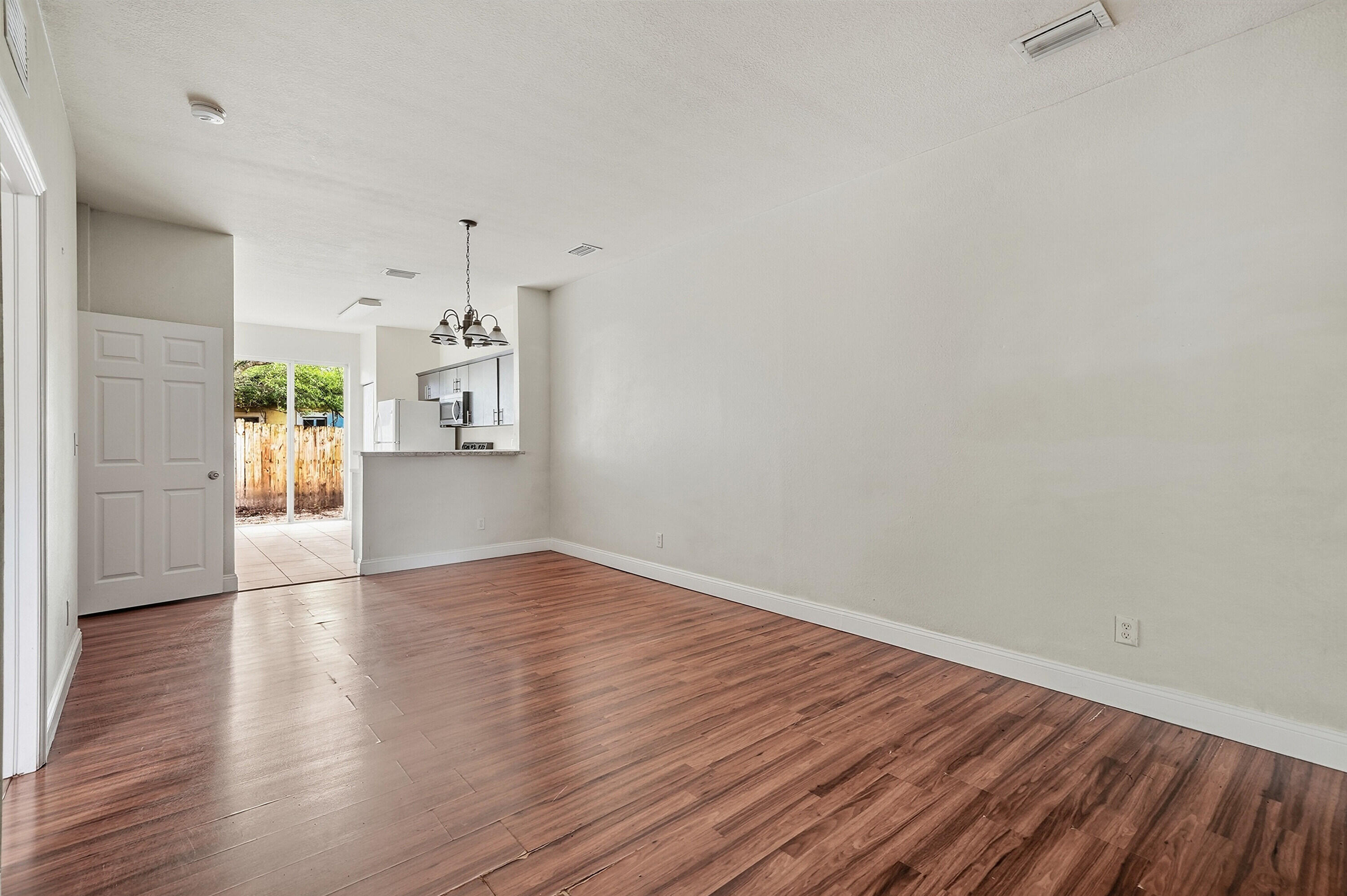 1584 Southwest 2nd Street Homestead, FL 33030 - Photo 11 of 28 a view of a big room with wooden floor and a kitchen