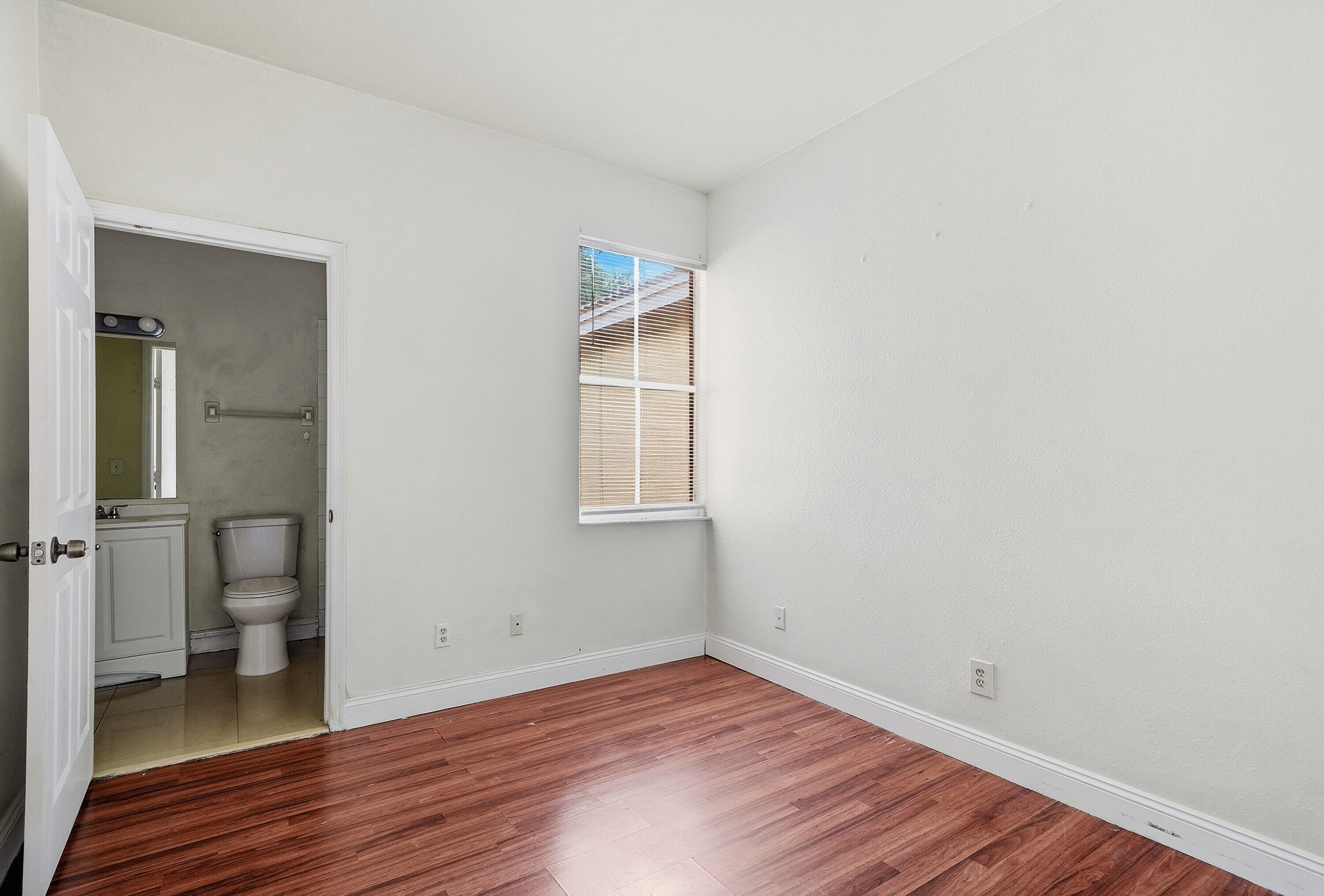 1584 Southwest 2nd Street Homestead, FL 33030 - Photo 13 of 28 a view of a room with wooden floor and a ceiling fan