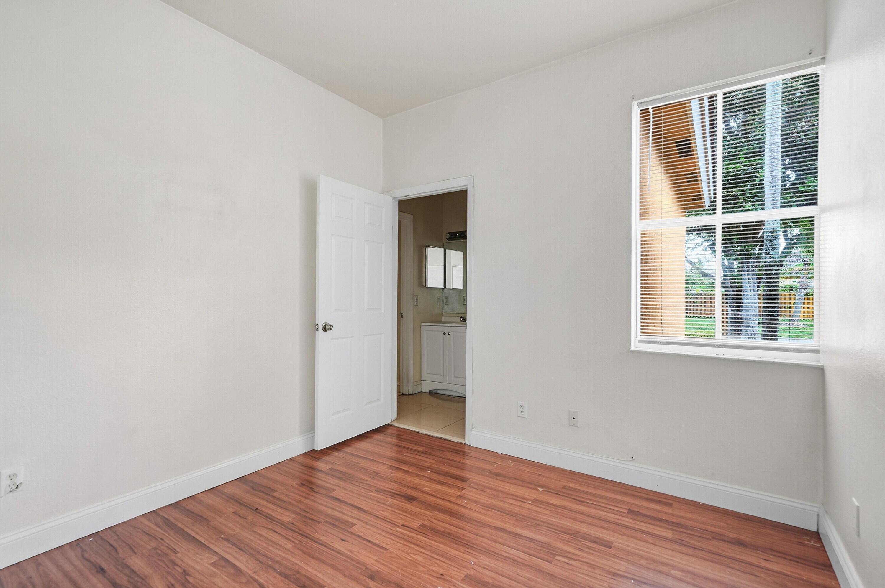 1584 Southwest 2nd Street Homestead, FL 33030 - Photo 15 of 28 a view of an empty room with wooden floor and a window