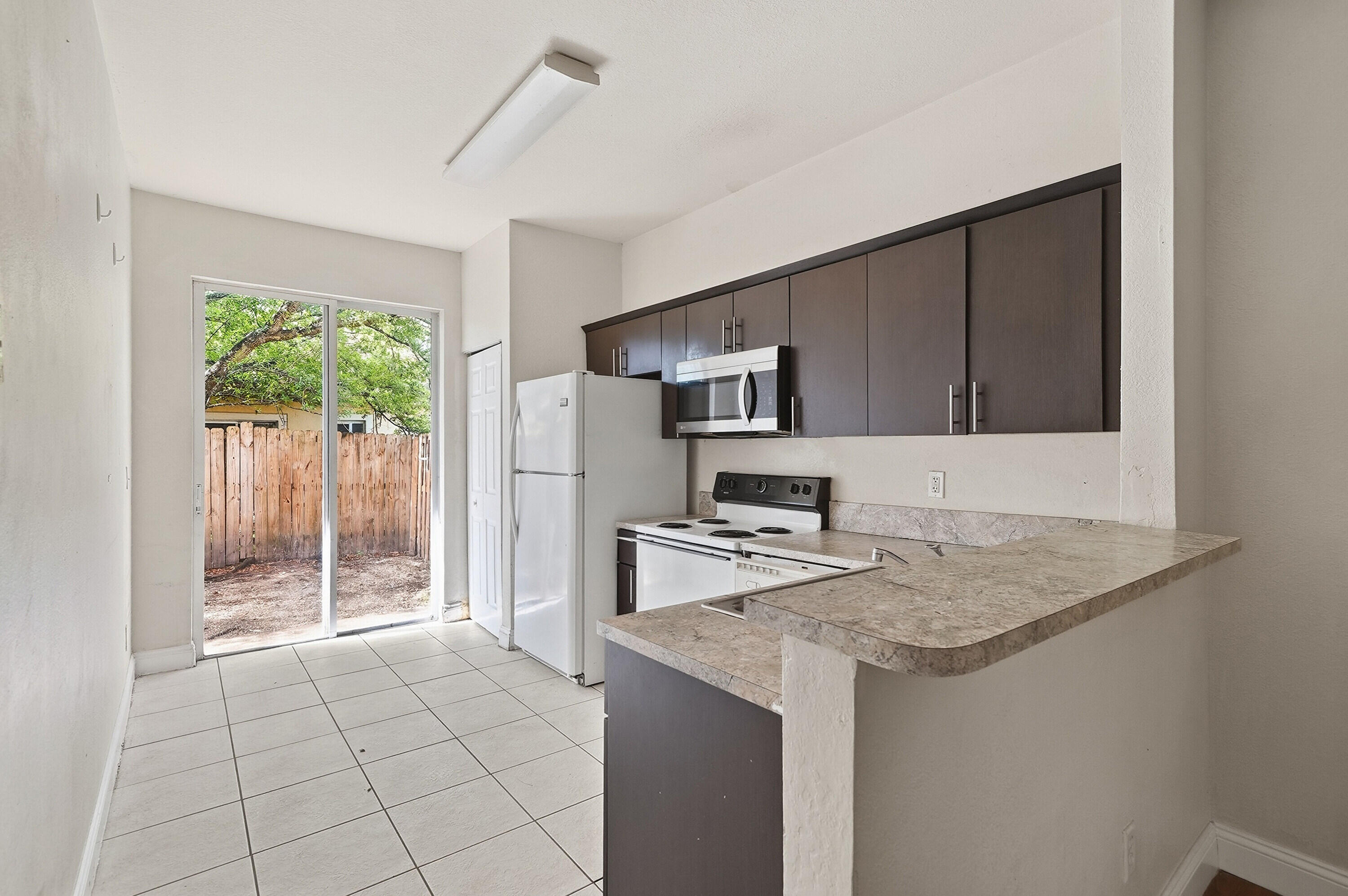 1584 Southwest 2nd Street Homestead, FL 33030 - Photo 2 of 28 a kitchen with stainless steel appliances granite countertop a sink stove and refrigerator
