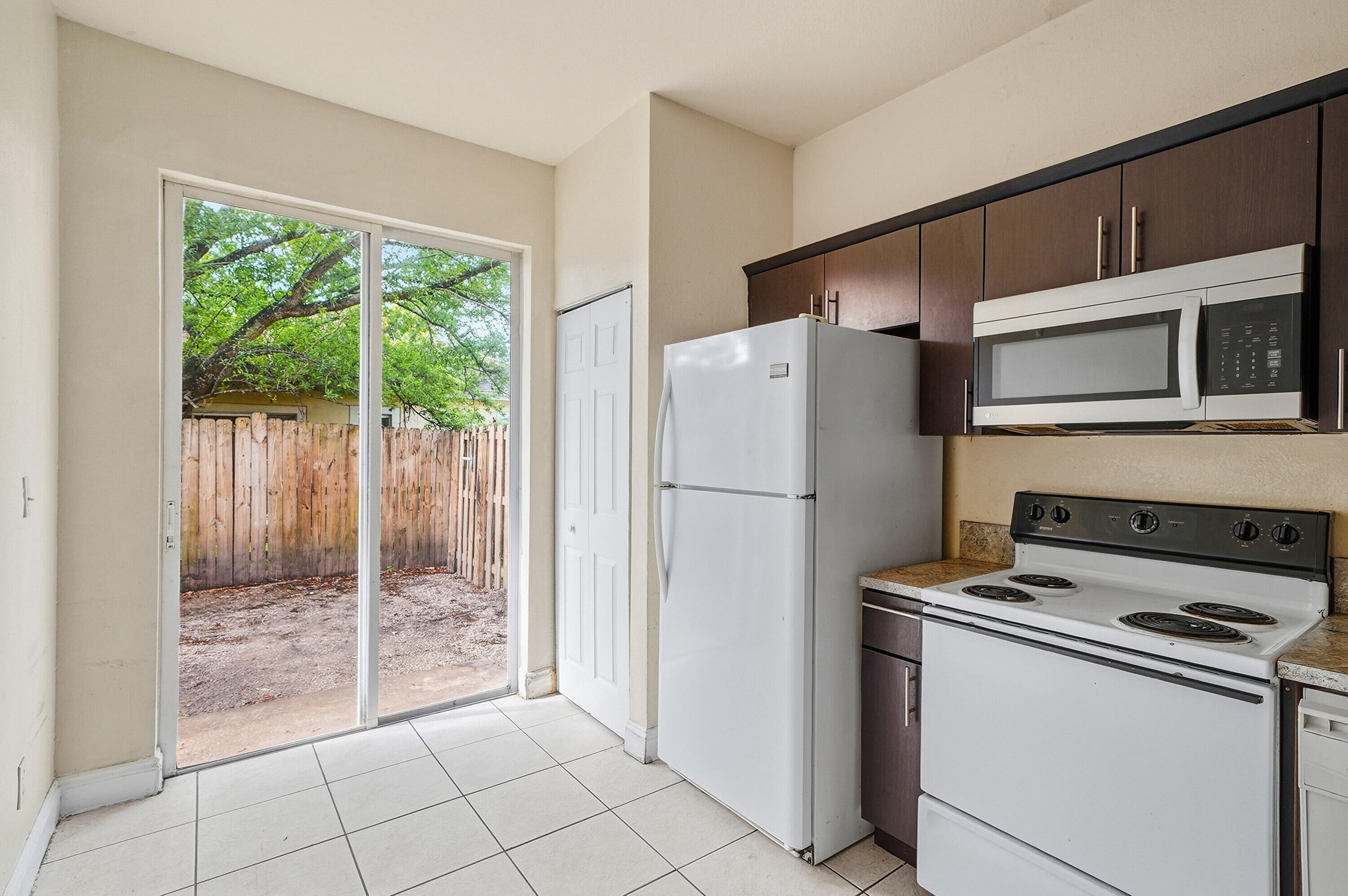 1584 Southwest 2nd Street Homestead, FL 33030 - Photo 4 of 28 a kitchen with a refrigerator a stove a washer and dryer