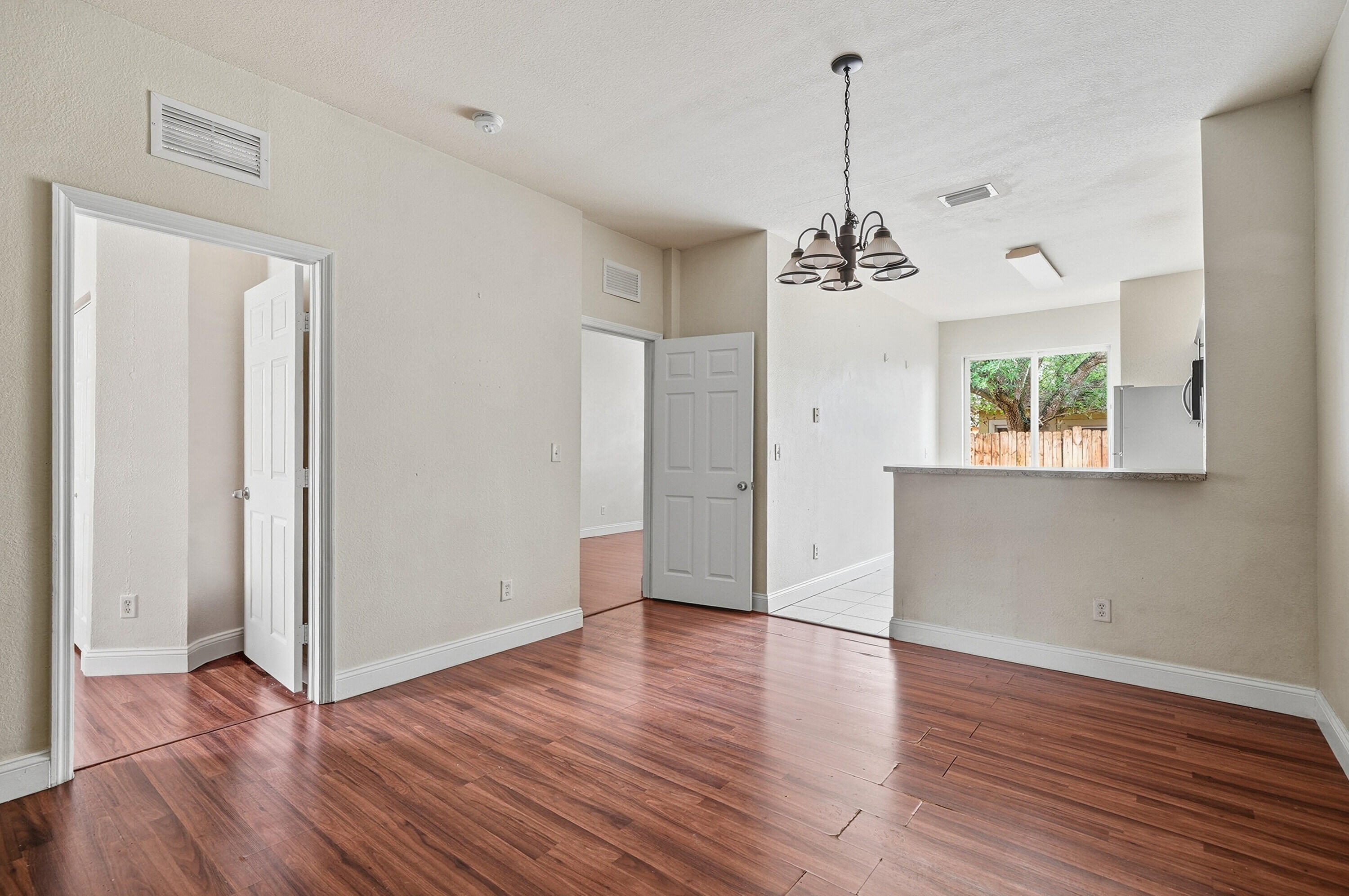 1584 Southwest 2nd Street Homestead, FL 33030 - Photo 7 of 28 a view of a room with wooden floor chandelier and a window