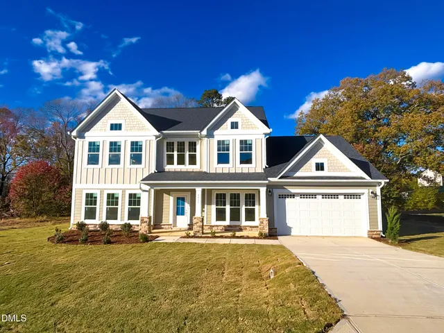 a front view of a house with a garden and yard