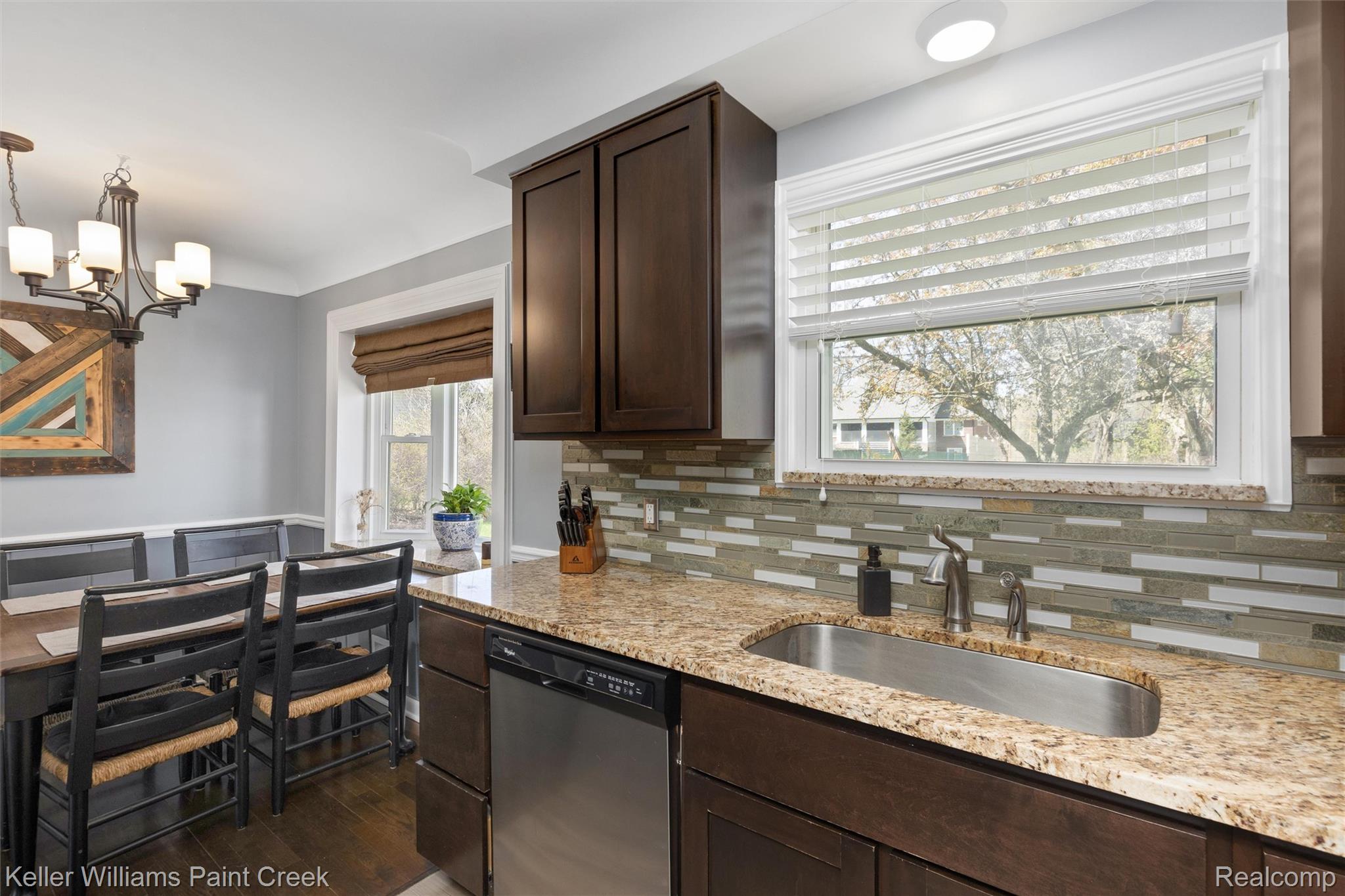 310 Elmhill Road Rochester, MI 48306 - Photo 7 of 37 Kitchen with dark wood finish cabinetry, dishwasher, light stone counters, dark wood-style flooring, and suspended lighting