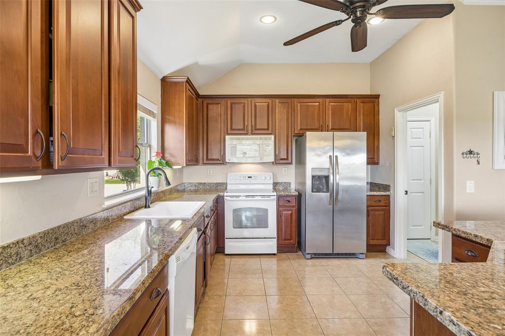 9221 Perimeter Street Denton, TX 76207 - Photo 10 of 36 a large kitchen with stainless steel appliances granite countertop a sink a stove and a refrigerator