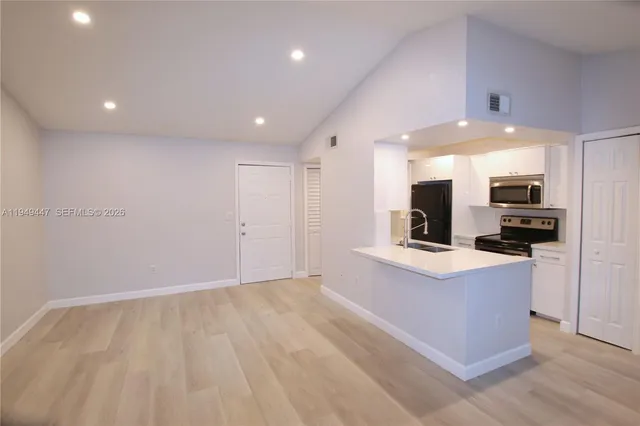 a view of kitchen with stainless steel appliances refrigerator stove microwave and refrigerator