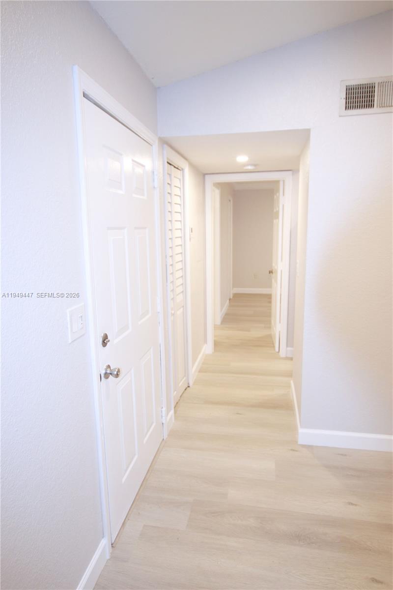 10681 Southwest 156th Place, Unit 402 Miami, FL 33196 - Photo 11 of 36 a view of a hallway with wooden floor and closet