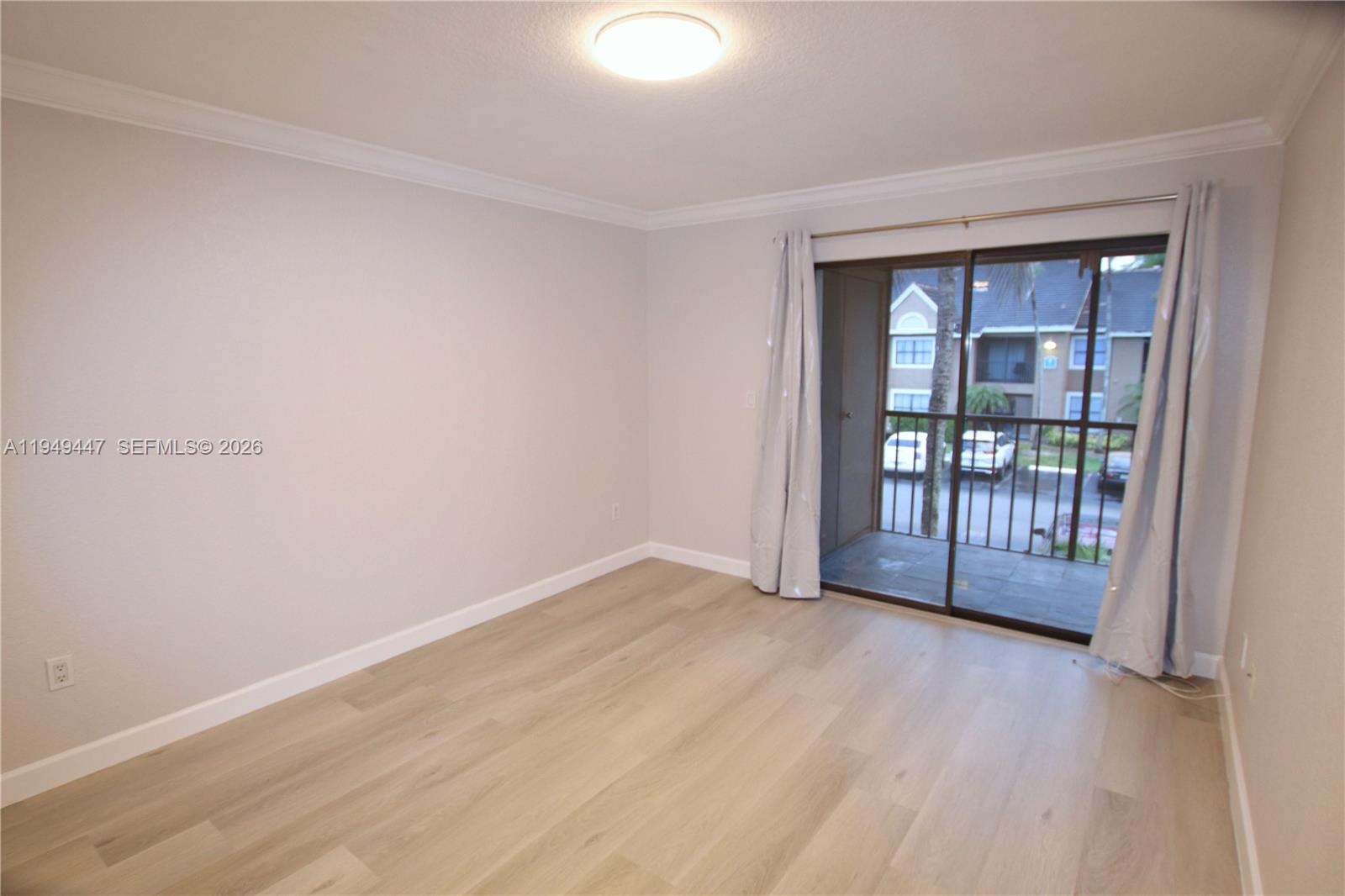 10681 Southwest 156th Place, Unit 402 Miami, FL 33196 - Photo 18 of 36 an empty room with wooden floor and windows