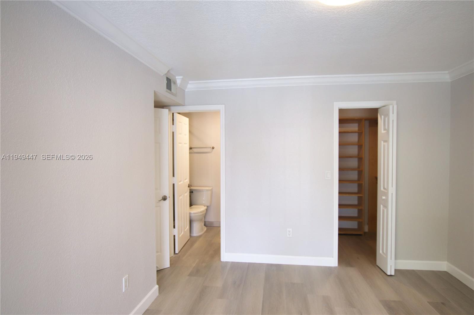 10681 Southwest 156th Place, Unit 402 Miami, FL 33196 - Photo 19 of 36 an empty room with wooden floor and closet