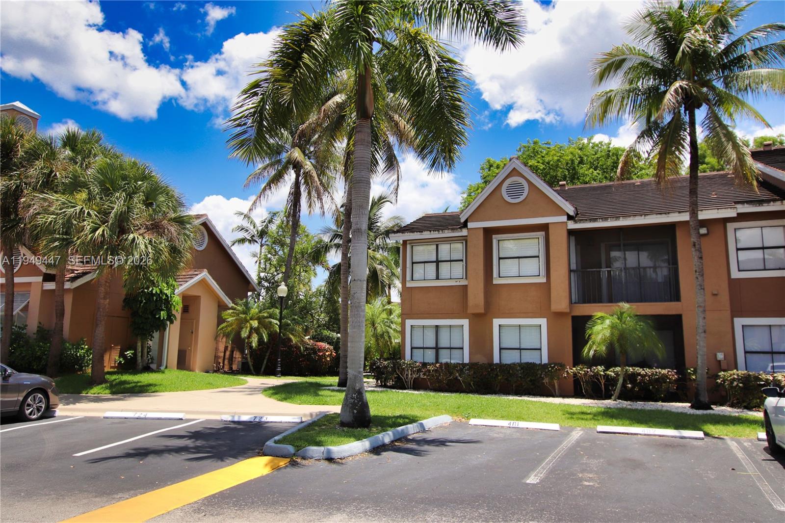 10681 Southwest 156th Place, Unit 402 Miami, FL 33196 - Photo 22 of 36 a front view of a house with a yard and palm trees