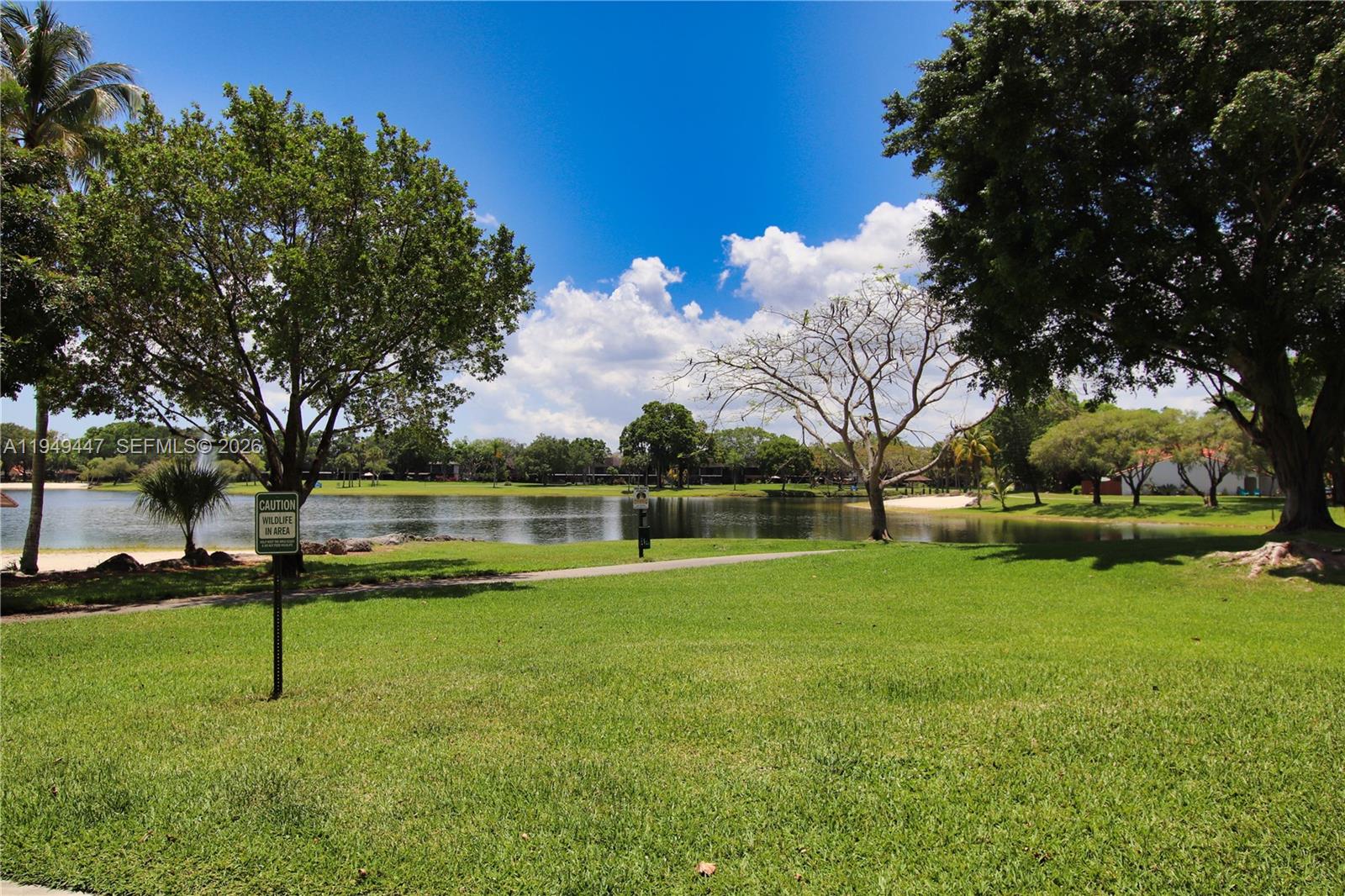 10681 Southwest 156th Place, Unit 402 Miami, FL 33196 - Photo 28 of 36 a swimming pool with lots of tress in front of it