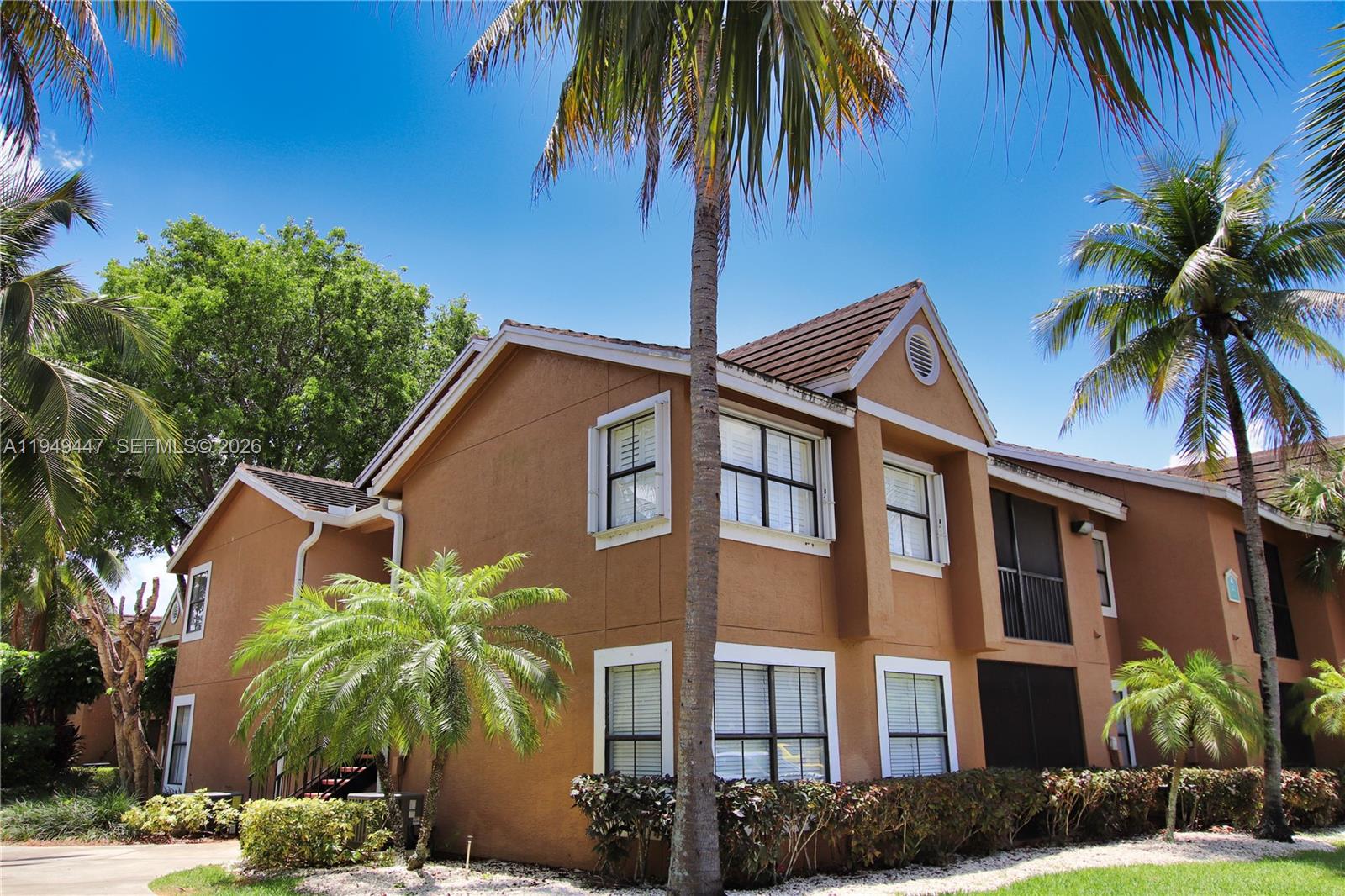 10681 Southwest 156th Place, Unit 402 Miami, FL 33196 - Photo 3 of 36 a front view of a house with a yard and potted plants