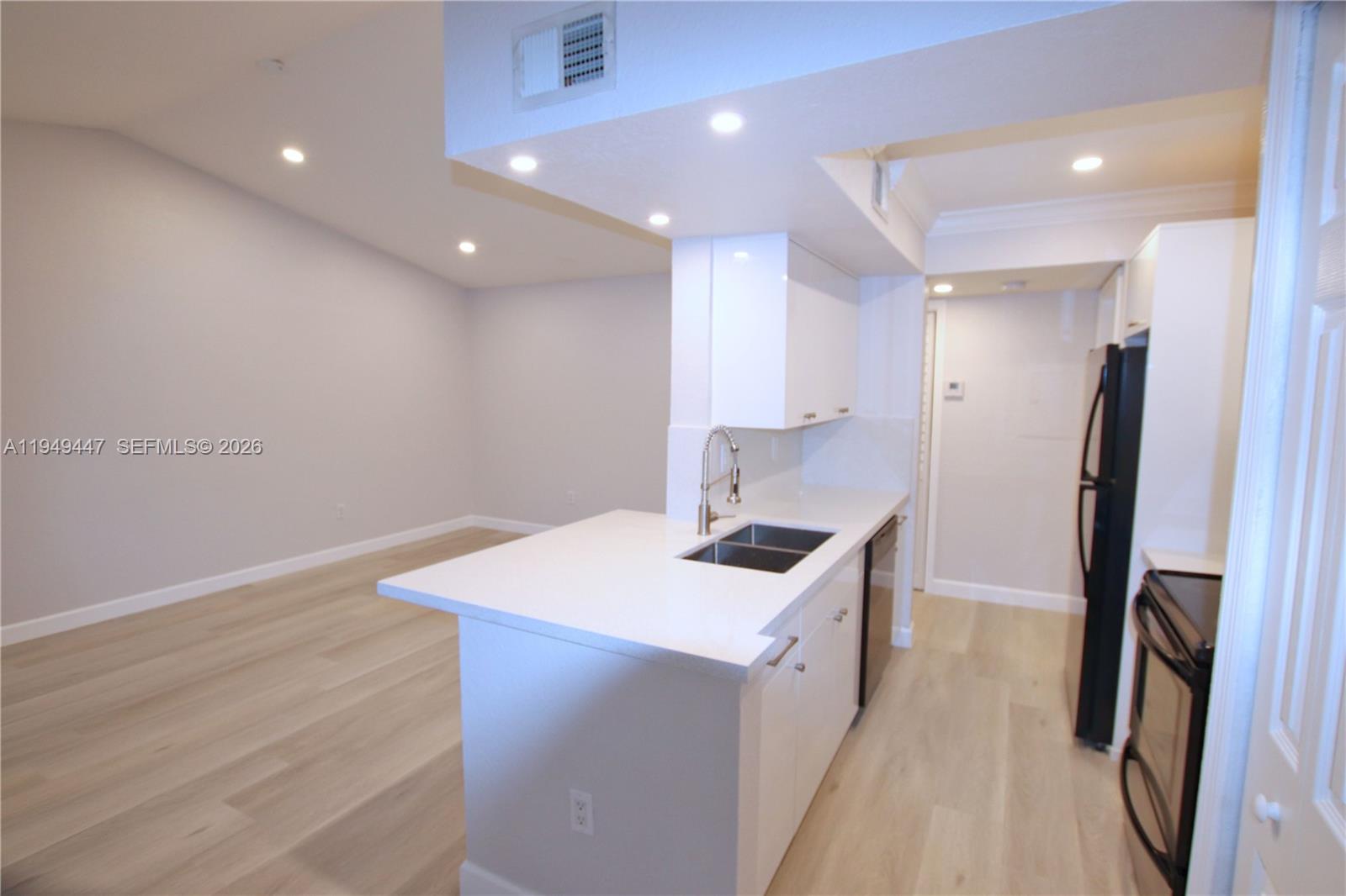 10681 Southwest 156th Place, Unit 402 Miami, FL 33196 - Photo 5 of 36 a kitchen that has a sink a refrigerator and a stove top oven