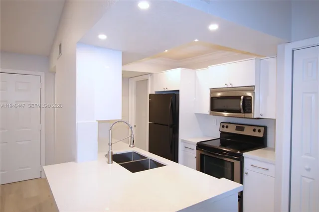 a kitchen with a refrigerator and a stove top oven
