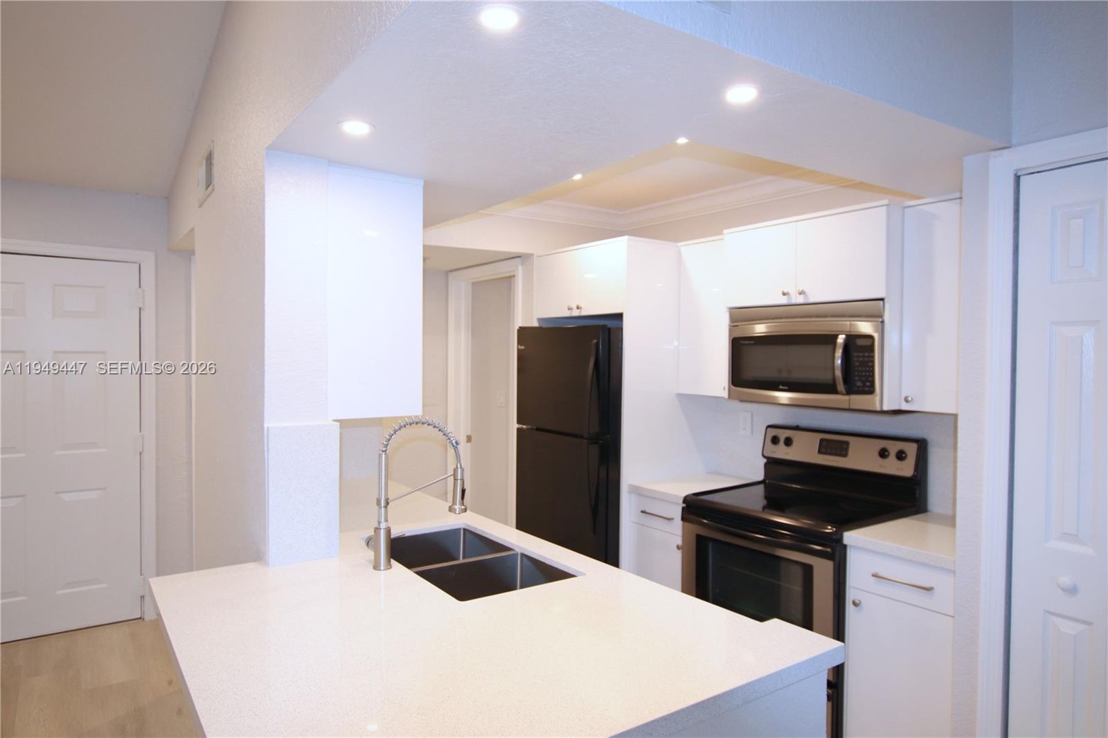 10681 Southwest 156th Place, Unit 402 Miami, FL 33196 - Photo 6 of 36 a kitchen with a refrigerator and a stove top oven